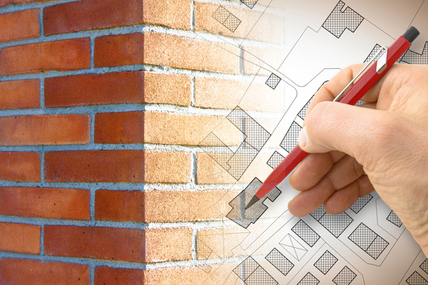 Faded image of bricking and hand writing on floor plans