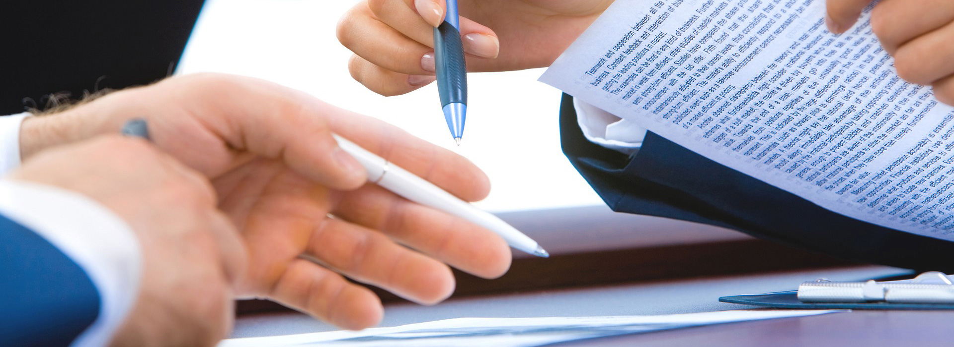 Two people comparing notes with pens in hand